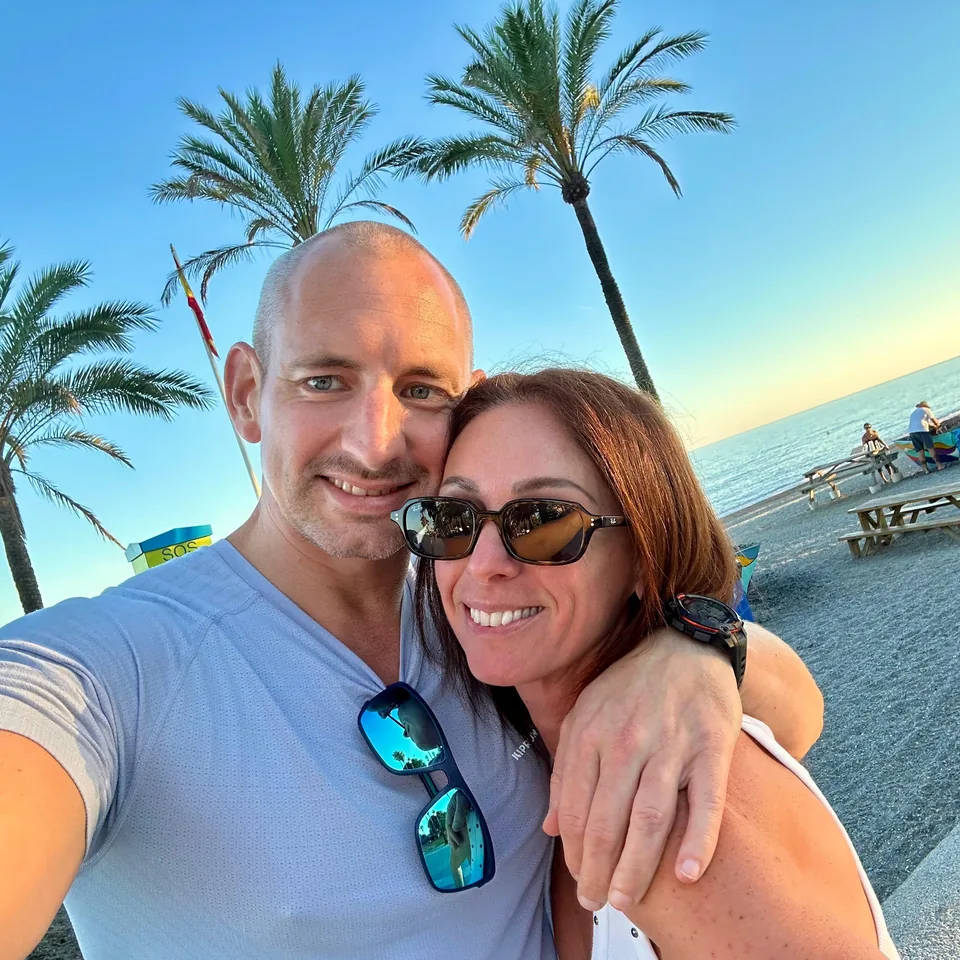Mark and Keely smiling together on the beach at sunset