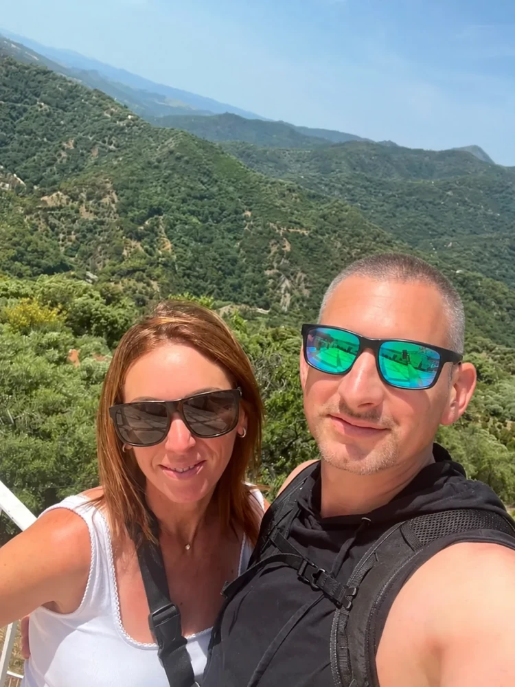 Mark and Keely smiling together on a sunny mountain walk
